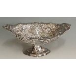 An oval sweetmeat dish, the body pierced, chased and embossed with scrolls and flowering foliage,