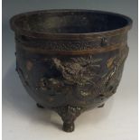 A late 19th Century Japanese bronze jardiniere of cylindrical form the rim cast with continuous