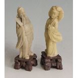 A pair of green soapstone figures of sages on brown soapstone bases, 10cm high,
