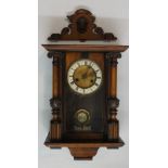 A small late 19th Century walnut Vienna wall clock the shaped fret cut pediment centred on a female