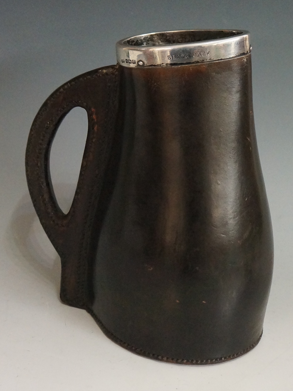 A silver mounted brown leather jack, the sturdy body and handle with thick stitching,