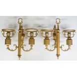 A pair of gilt metal wall lights the Rococo shaped cast back plates issuing fluted fore post with