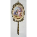 A late 19th Century French oval hand mirror the oval porcelain back painted with a courting couple