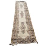 A Persian Kirman runner, three floral yellow and blue medallions on cream ground,