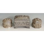 An Indian silver coloured metal casket of rectangular form the hinged lid embossed with a panel of