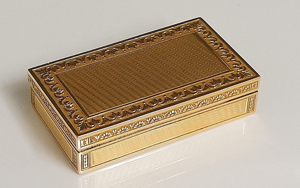 A 19th Century French gold box the hinged lid with finely engine turned rectangular centre within