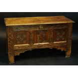 A late 17th Century oak blanket chest the plain two plank top above a frieze carved with stylised