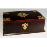 A late Victorian brass bound stained mahogany cigar box, the hinged lid with strapwork mounts,