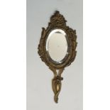 A French Rococo style hand mirror, the metal mount cast with flourishes of scrolling foliage,