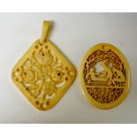 Two ivory pendants one pierced and carved with three rose blooms within pierced border,