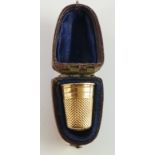 A 19th Century gold coloured metal thimble in fitted velvet lined red Morocco leather case,