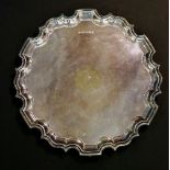 A plain silver salver with pie crust rim, three ball and claw feet, by Carr's of Sheffield Ltd,