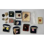 A selection of brooches, painted bone china flowers from brands such as Coalport,