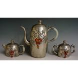 A Chinese pewter three piece tea service of rounded oval form the bodies applied leafage and