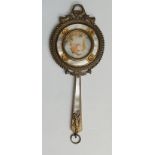 An Art Nouveau ormolu mounted hand mirror with mother of pearl decoration and central portrait of a