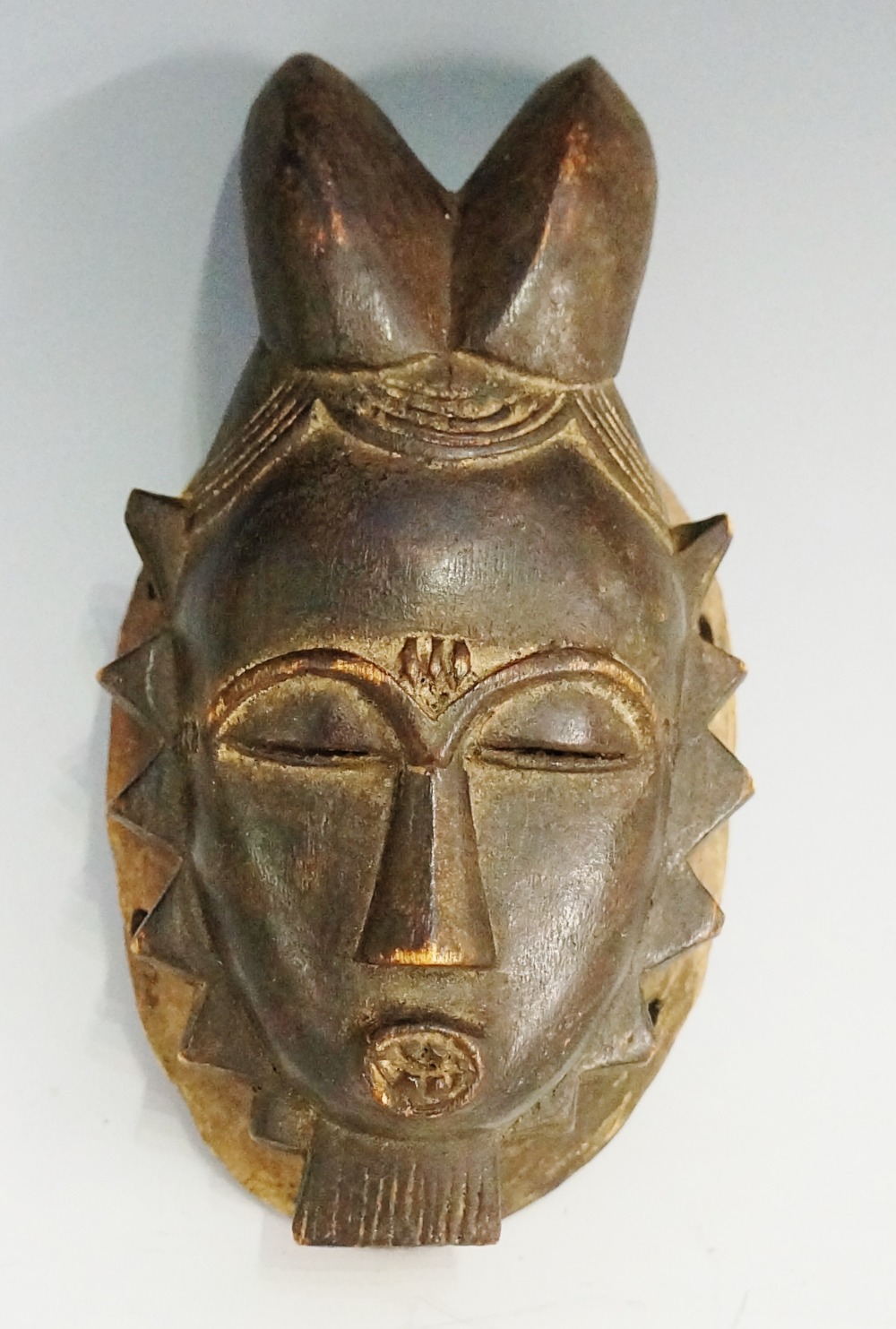 A small tribal mask, the stylistically c