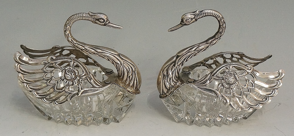 A pair of unusual swan form salt cellars with silver heads, necks and wings,