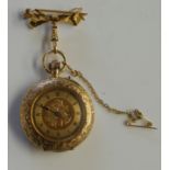 A small gold pocket watch, foliate engraved, inside back marked 18ct 75, with safety chain and fob,