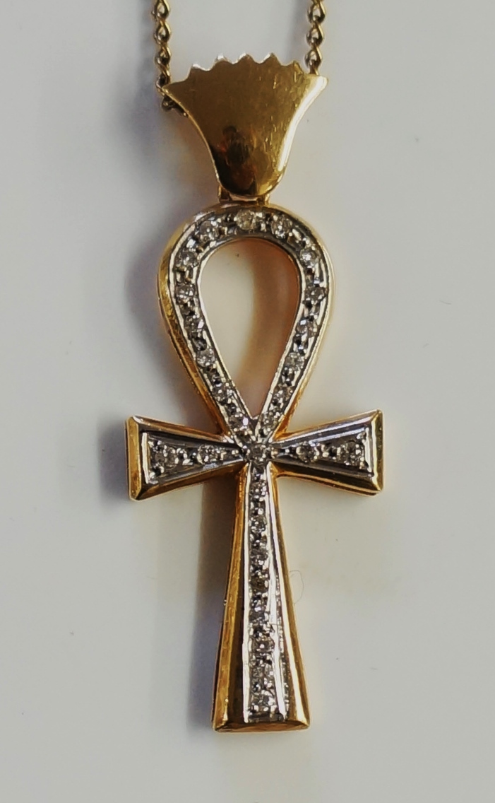 A yellow metal pendant in the form of an