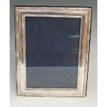 A silver fronted photo frame, reeded rim