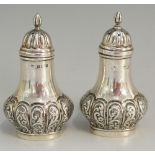 A pair of silver pepperettes, the lower