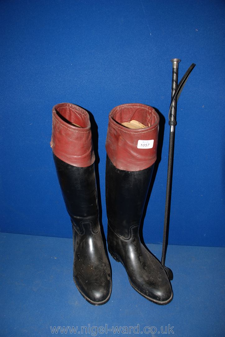 A pair of black and tan Riding Boots with a Whip