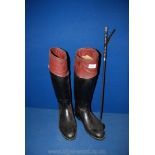 A pair of black and tan Riding Boots with a Whip