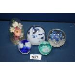 Four Paperweights including two by Laugharne Glass and a small flower arrangement in a dome