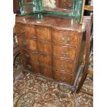 A reproduction Walnut finished Queen Anne serpentine style Chest of four graduated drawers,