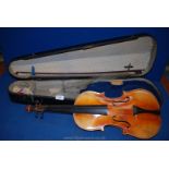 An old Violin in a wooden case with single bow.