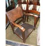 A circa 1920 Oak framed low elbow Chair with nailed brown leather upholstered back,