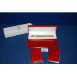 A boxed Cartier De Must gold coloured Pen with paperwork.