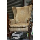 A Parker Knoll Froxfield fireside Armchair with wing back in gold ground floral shadow pattern