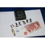 A metal box containing an old ten shilling note, lead free figures,