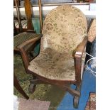 An arts and crafts Oak Nursing Chair having hooped back, low tapering arms,