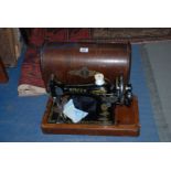 A wooden cased Singer Hand Sewing Machine no F9731048 with a key