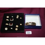 A box containing seven pairs of earrings and a gold coloured bangle unmarked