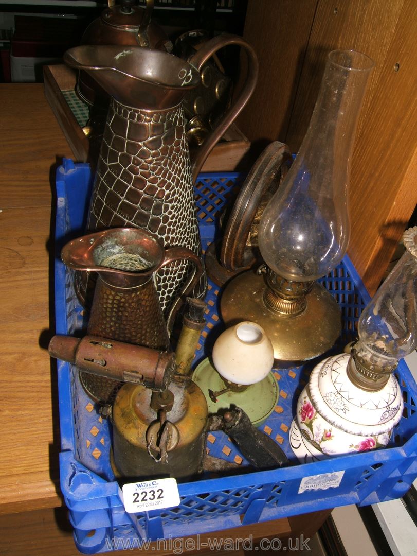 A quantity of copper and brass items including two jugs, blow lamp, bell, oil lamp,