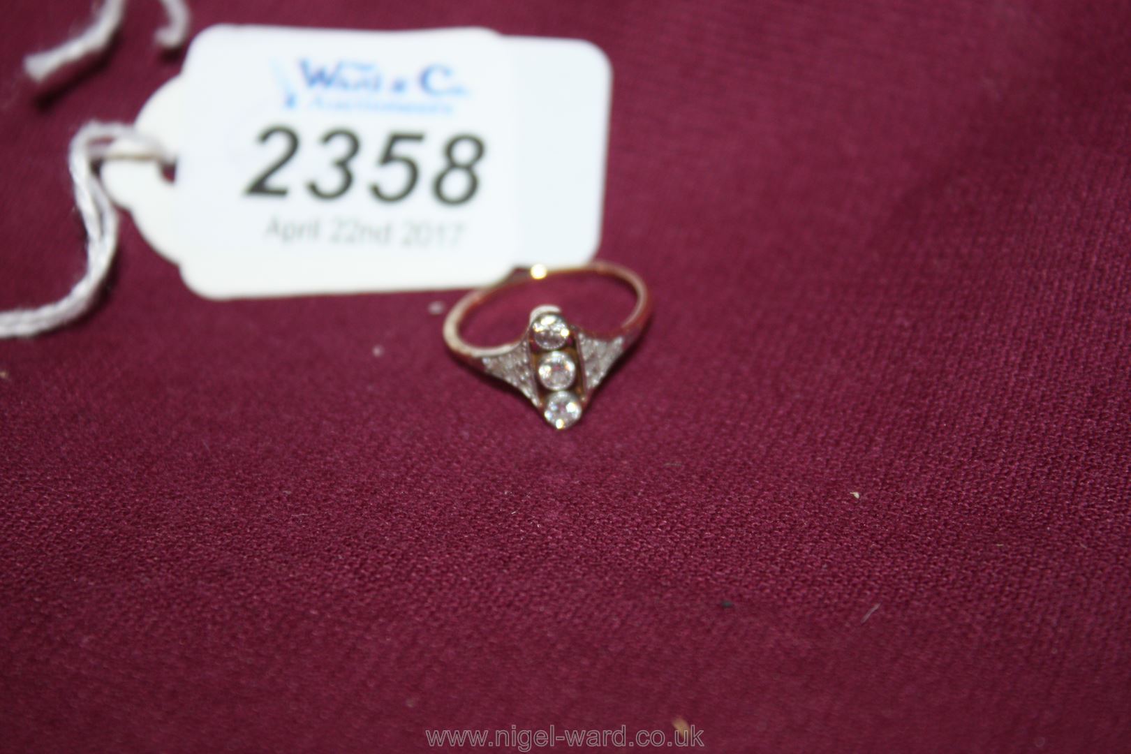 A Gold, three stone diamond Ring with diamond chips to the shoulders.