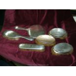 A Silver back hand Mirror with two matching Brushes,