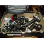 A large quantity of Lenses and a Praktica Camera and a camera bag