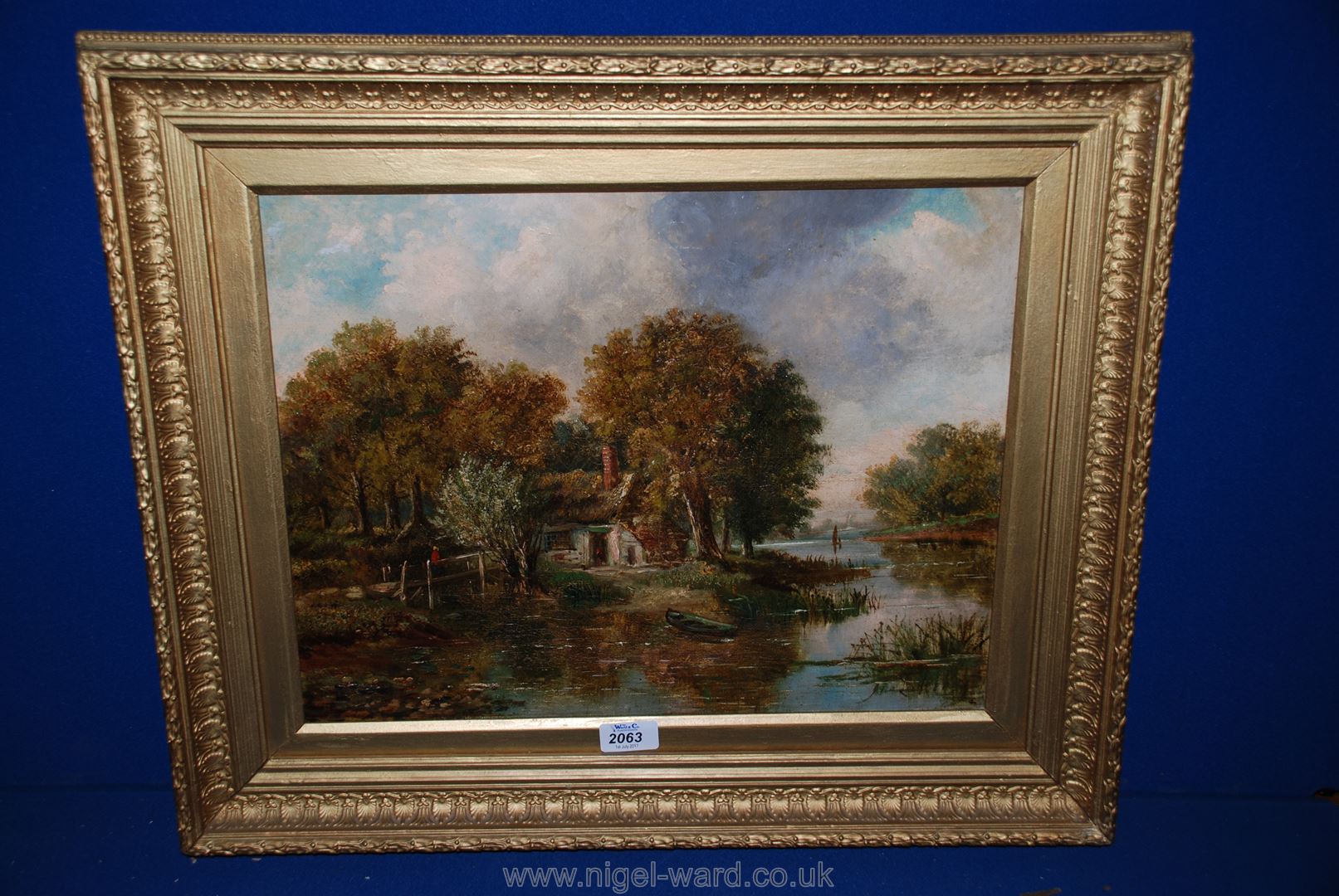 An Indistinctly signed Oil on canvas of a river cottage