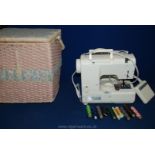 A Singer compact free-arm Sewing Machine in small basket, threads, manual, etc.