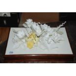 A white china encrusted floral Spray centrepiece with daffodils, roses, iris, etc.