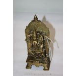 An Indian brass and silver inlaid shrine of Vishnu riding Garuda with Parvati on his knee,