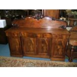 A Victorian Mahogany Sideboard with carved and moulded upstand back over three frieze drawers and