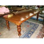 A Victorian Mahogany wind-out extending Dining Table having round cornered top and standing on