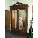 A French Chestnut Armoire c1880 having cornice over a pair of mirrored doors having column detail