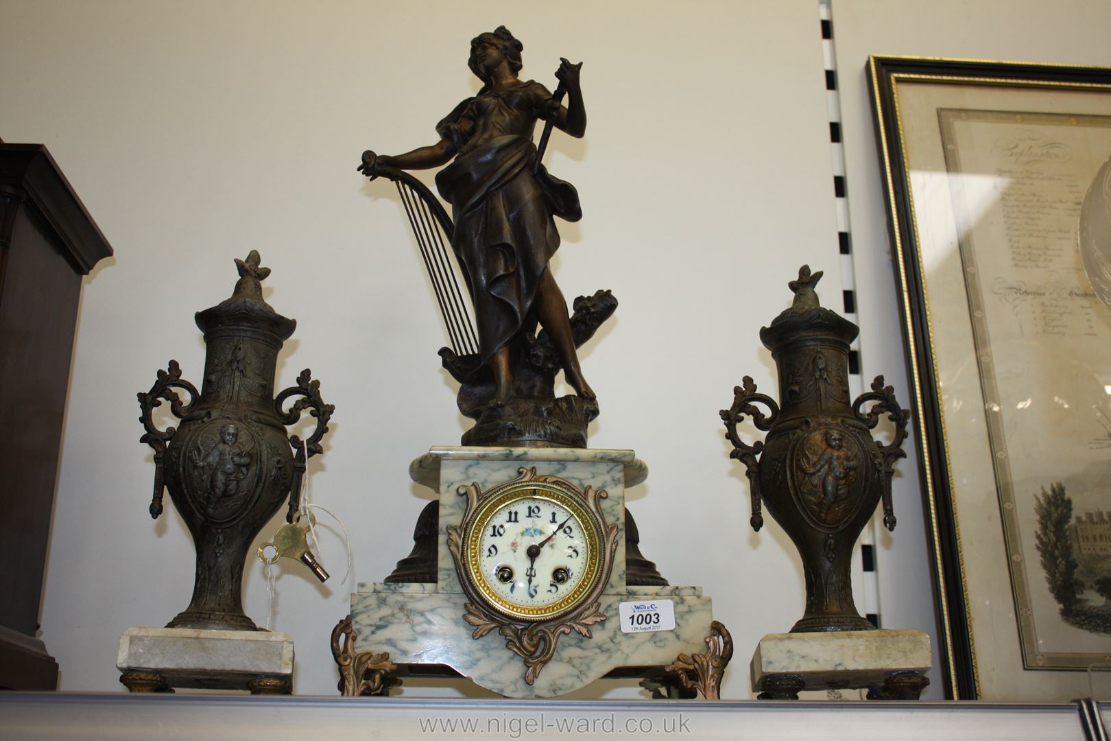 A French Clock Garniture with enamelled dial clock having eight day striking movement,