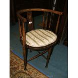 An Edwardian beech Corner Tub Chair with spindle back, applied seat and standing on turned legs.